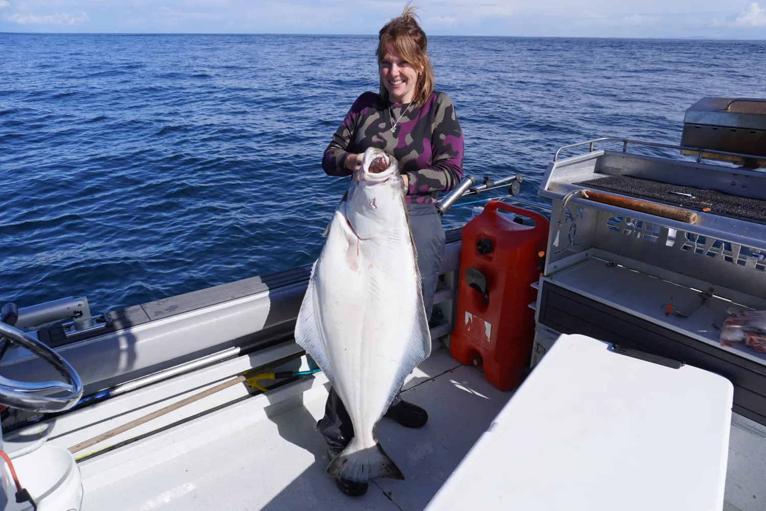 Guest holding a halibut on the boat