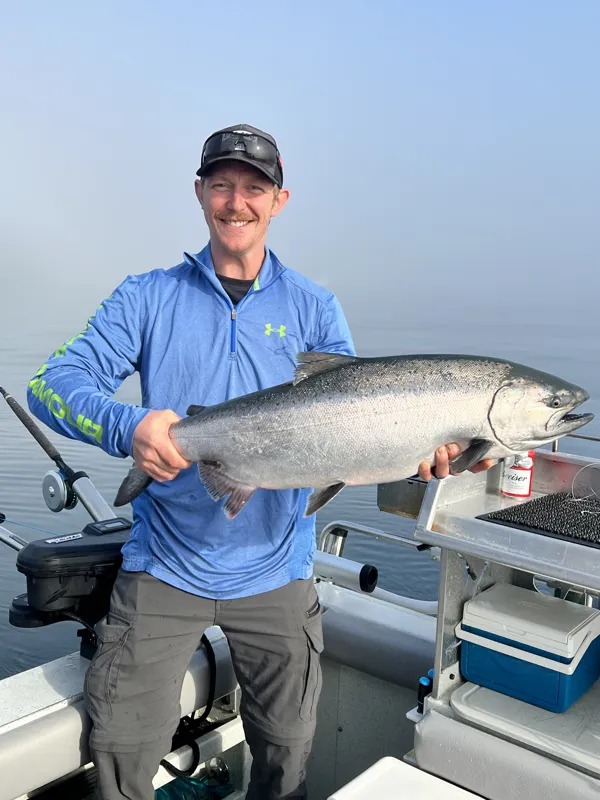 Guest holding a salmon aboard a DC Charters trip
